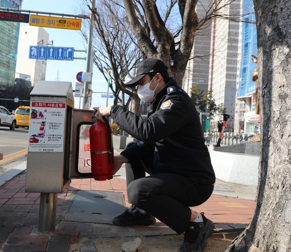 가로변 비상용 소화기함을 점검하고 있는 모습임. 