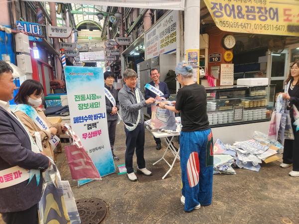 정규용 도시정책국장 등 시 관계자와 상인회원들이 방문객들에게 폐현수막을 새활용한 장바구니를 무료로 나누어 주며 전통시장 이용 활성화 캠페인을 펼치고 있다.